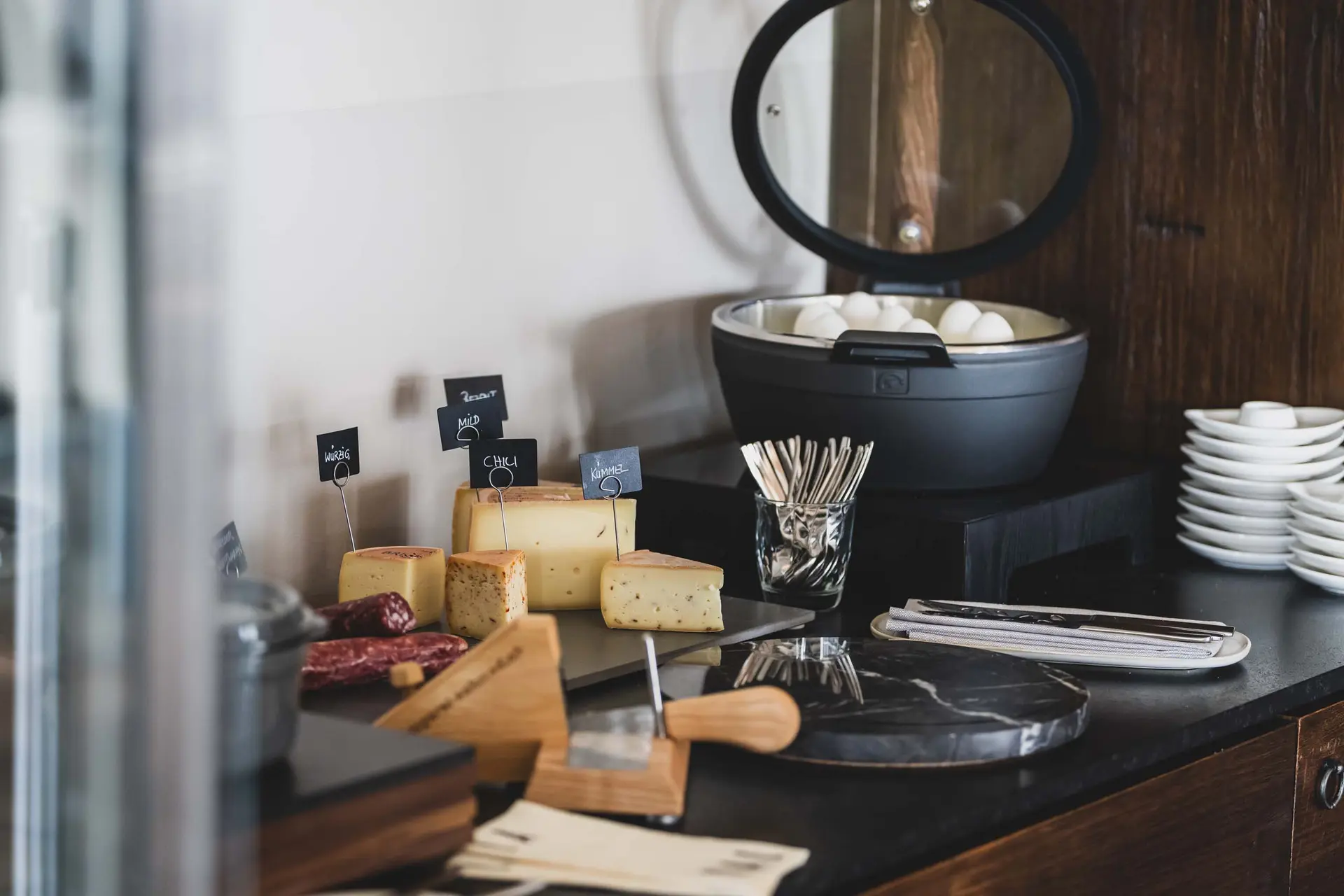 Eindrücke aus dem La Val Hotel & Spa Verschiedene Käsesorten und gekochte Eier in einem Buffet-Setup