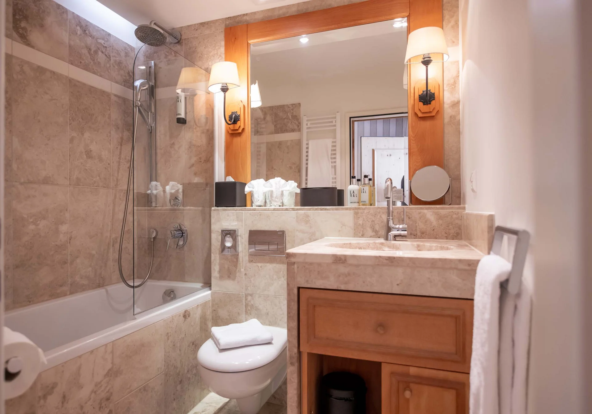 Modernes Badezimmer mit Badewanne, Waschbecken, Toilette und großem Spiegel