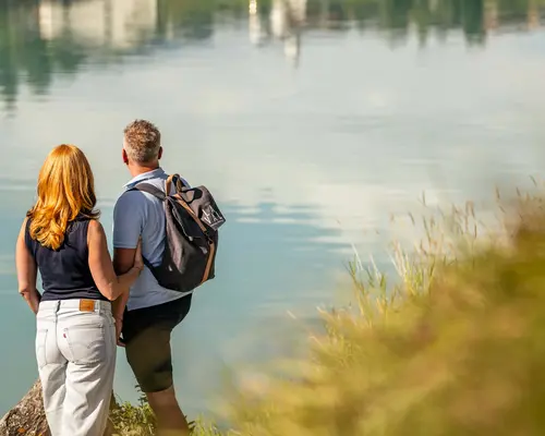 Storys aus dem La Val Hotel & Spa Paar steht am Ufer und blickt auf ruhigen See mit Spiegelung