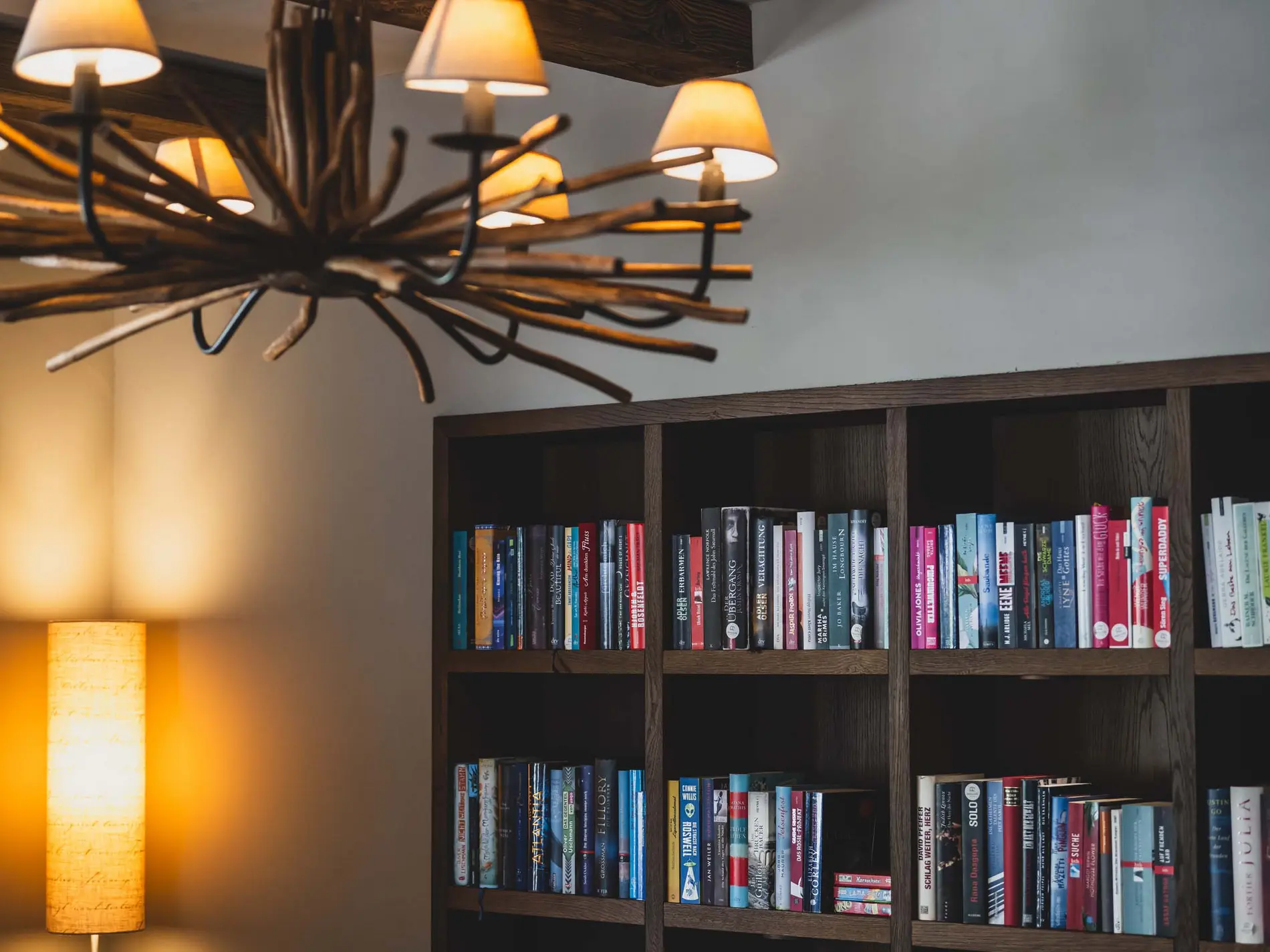 Kulinarische Vielfalt in unseren Restaurants in Brigels Gemütliche Leseecke mit Bücherregal und rustikaler Holzlampe