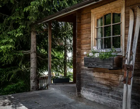 Kulinarische Vielfalt in unseren Restaurants in Brigels Gemütlicher Essbereich mit kariertem Tisch, Holzwänden und Wandofen