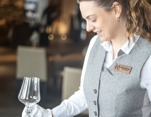 Kellnerin putzt ein Weinglas im Restaurant