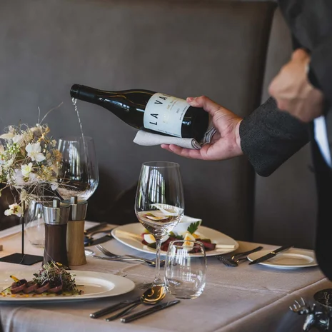Kellner gießt Wein in ein Glas bei einem eleganten Restaurantessen