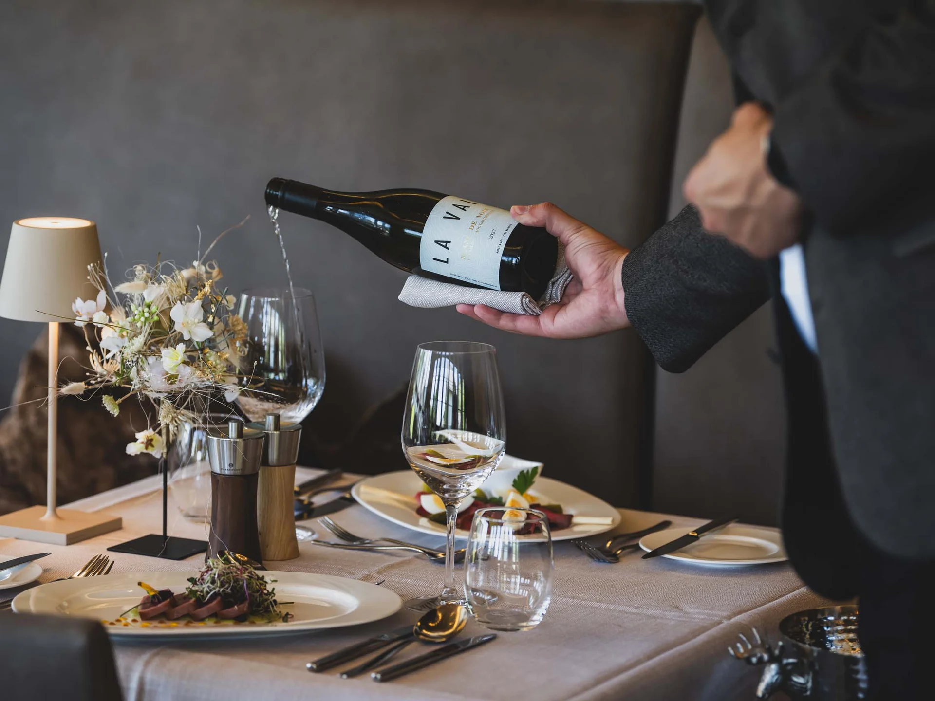 Kellner gießt Wein in ein Glas bei einem eleganten Restaurantessen