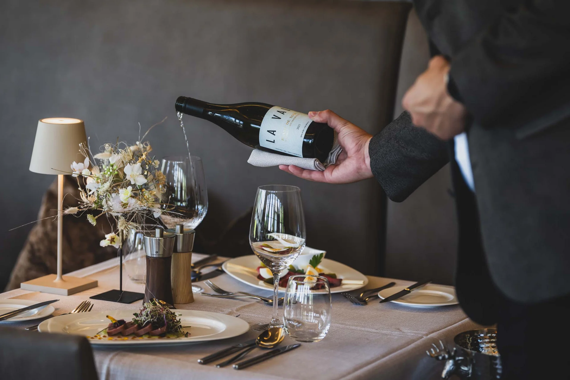Kellner gießt Wein in ein Glas bei einem eleganten Restaurantessen