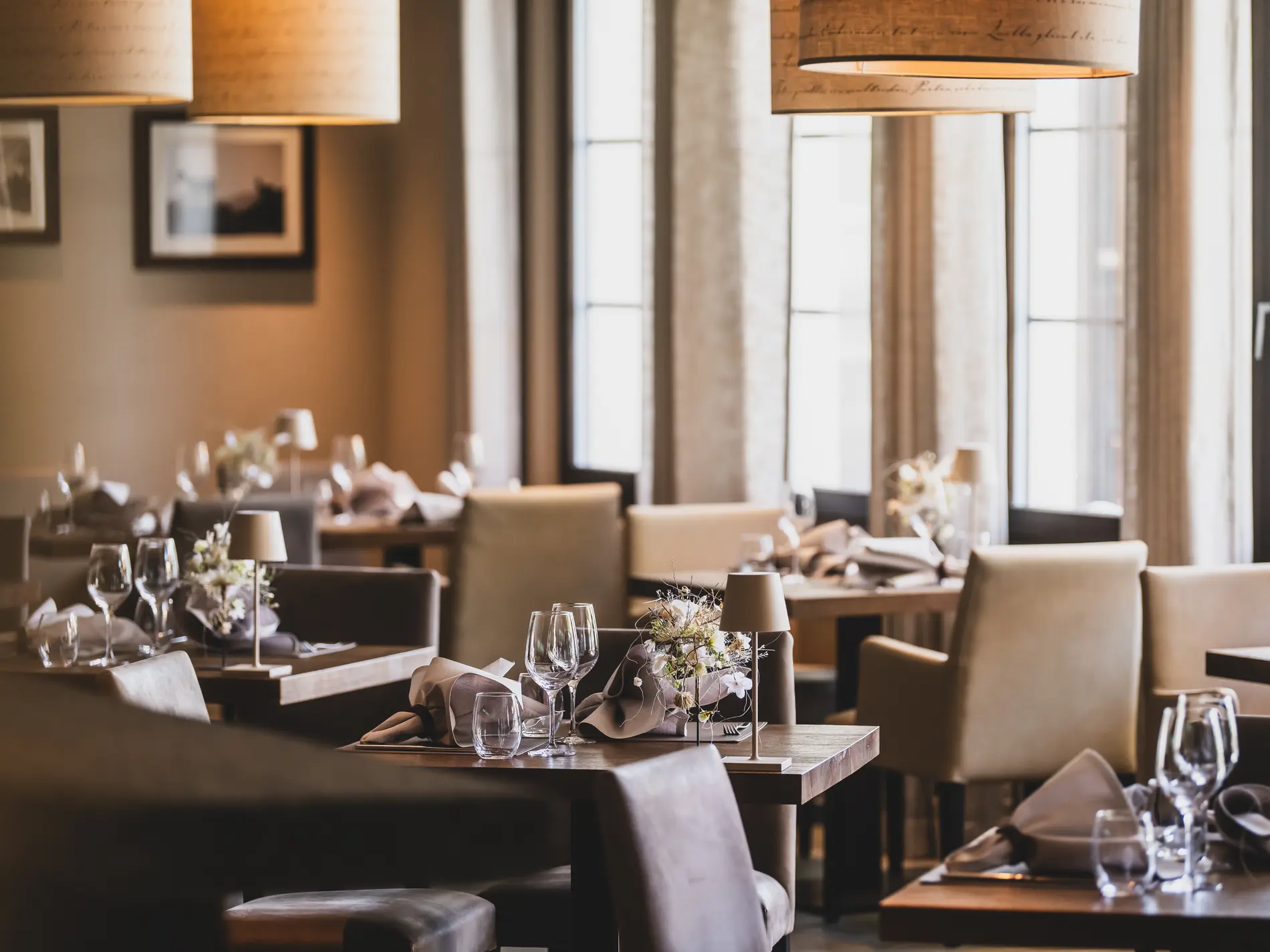 Kulinarische Vielfalt in unseren Restaurants in Brigels Elegantes Restaurant mit gedeckten Tischen und warmem Licht