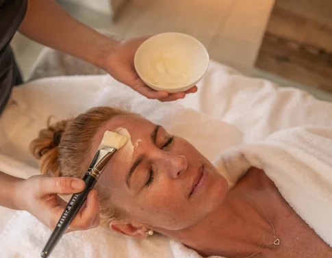Frau erhält Gesichtsmaske bei Schönheitsbehandlung im Spa
