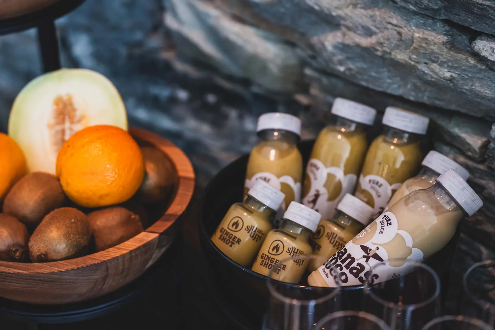 Eindrücke aus dem La Val Hotel & Spa Flaschen mit Ingwershots und Bananen-Kokos-Saft neben Schale mit Obst