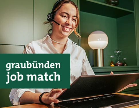 Frau mit Headset arbeitet an Laptop in modern grünem Büro