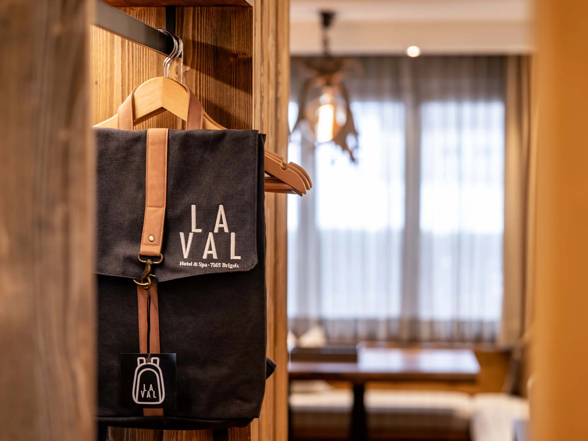 Schwarze Tasche mit LA VAL Logo hängt an einem Kleiderbügel im Hotelzimmer