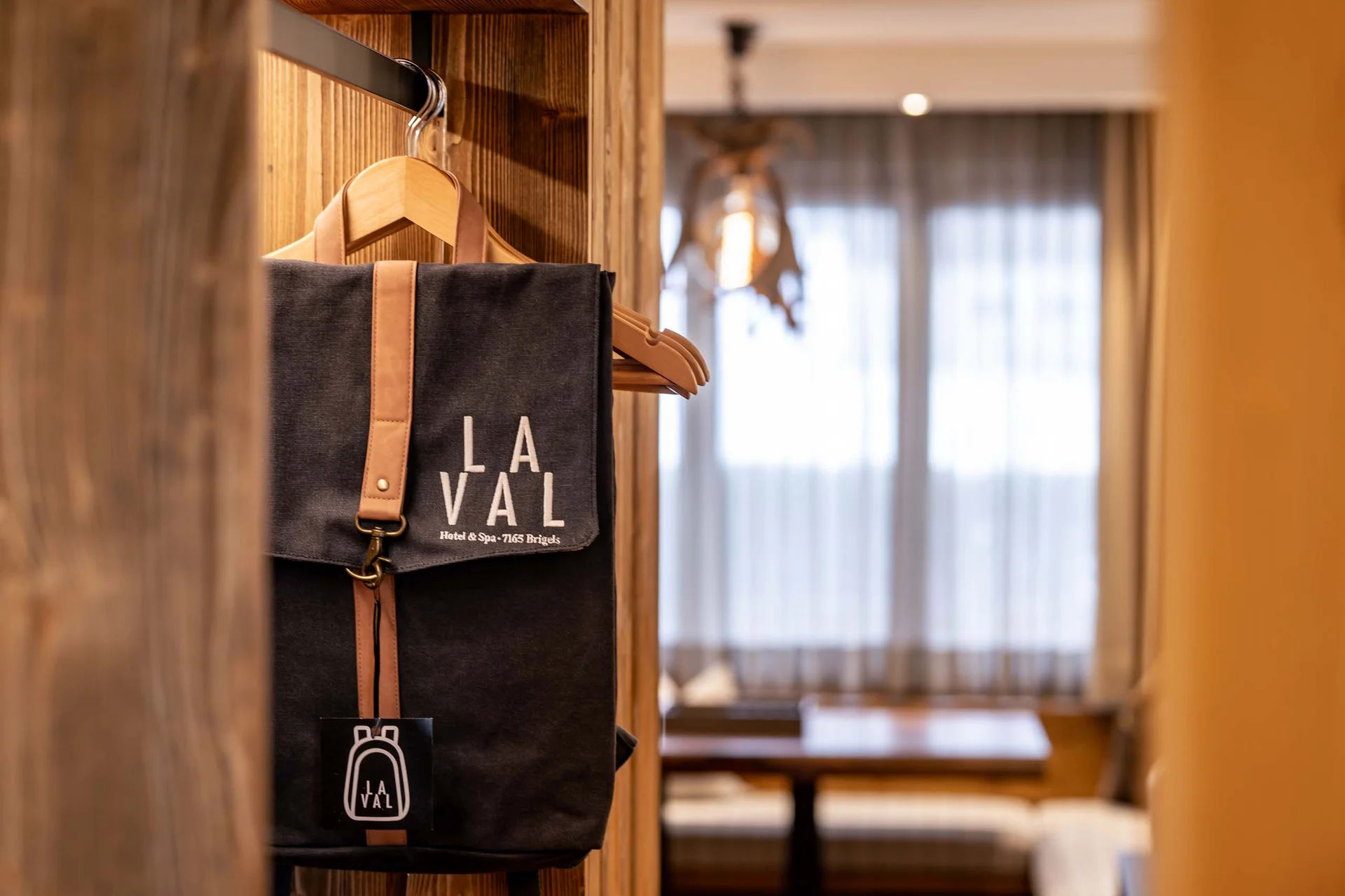Schwarze Tasche mit LA VAL Logo hängt an einem Kleiderbügel im Hotelzimmer