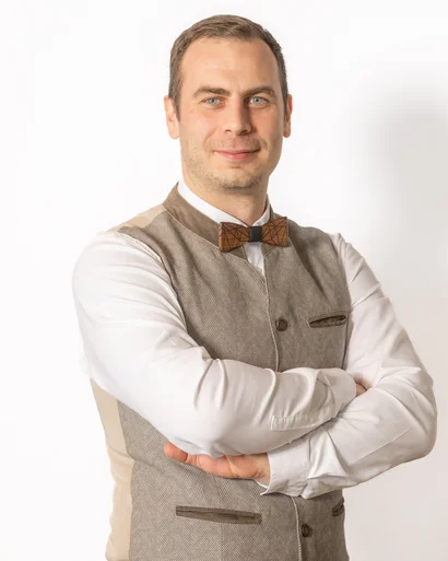 Mann mit kariertem Weste und Fliege vor weißem Hintergrund