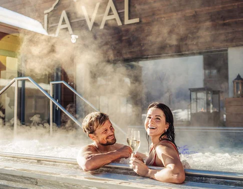 Paar genießt Champagner in Außenwhirlpool mit Dampf im Spa-Resort