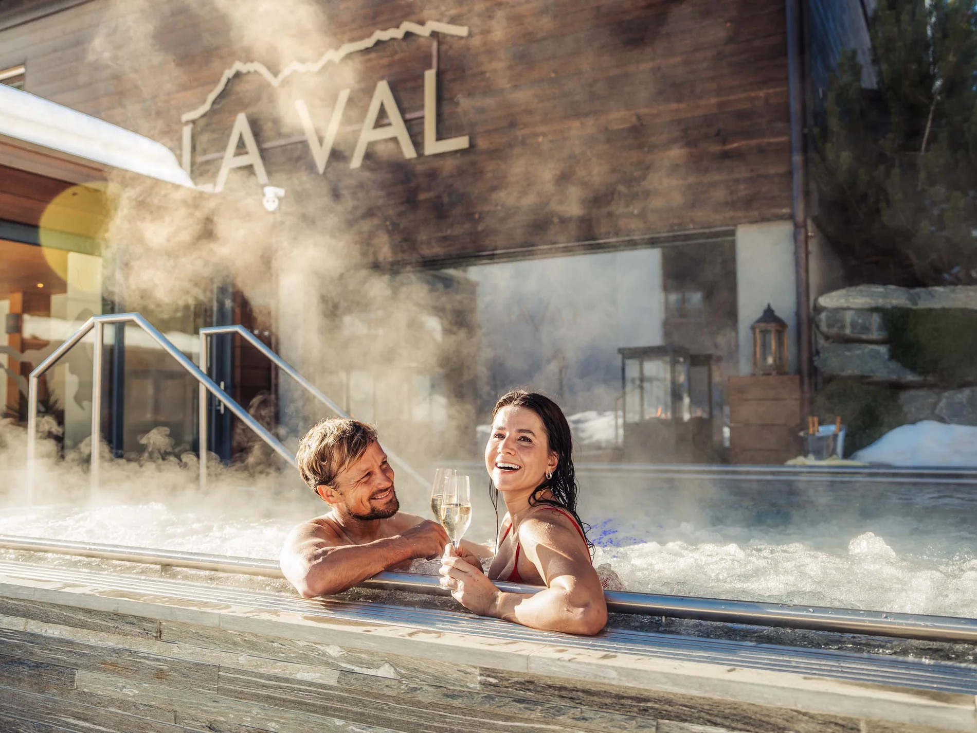 Paar genießt Champagner in Außenwhirlpool mit Dampf im Spa-Resort