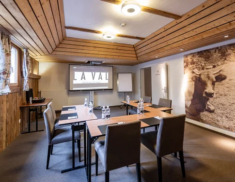 Konferenzraum mit Holzverkleidung, Stühlen und Präsentationsbildschirm