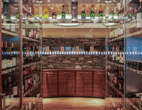 Moderner Weinkeller mit Glastüren und integriertem Kaminfeuer