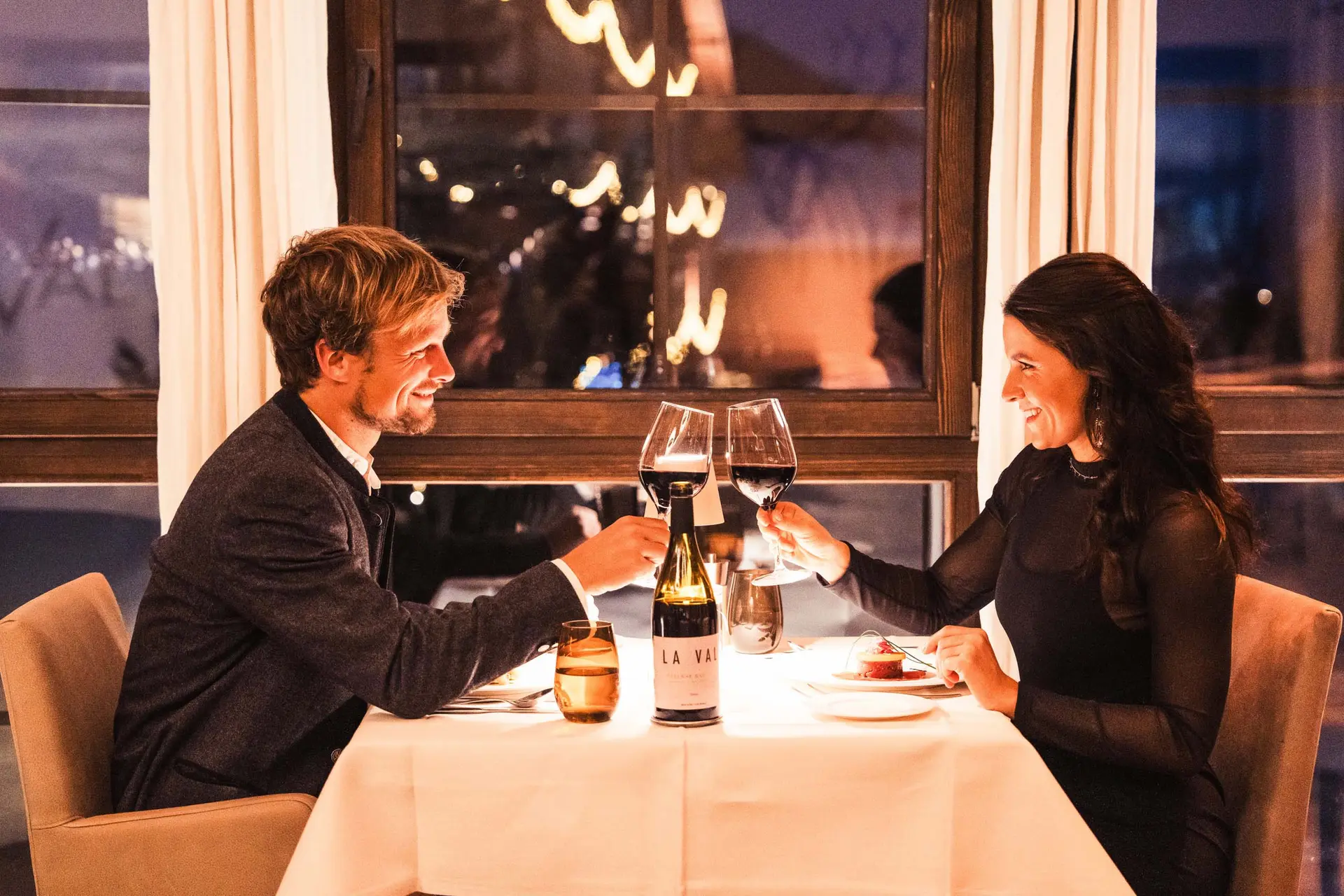 Paar stößt mit Wein in einem gemütlichen Restaurant an
