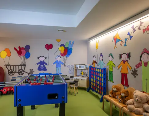 Traumhaft Übernachten in Breil/Brigels Kinderspielzimmer mit Tischfußball, Wandmalerei und Kuscheltieren auf Stühlen