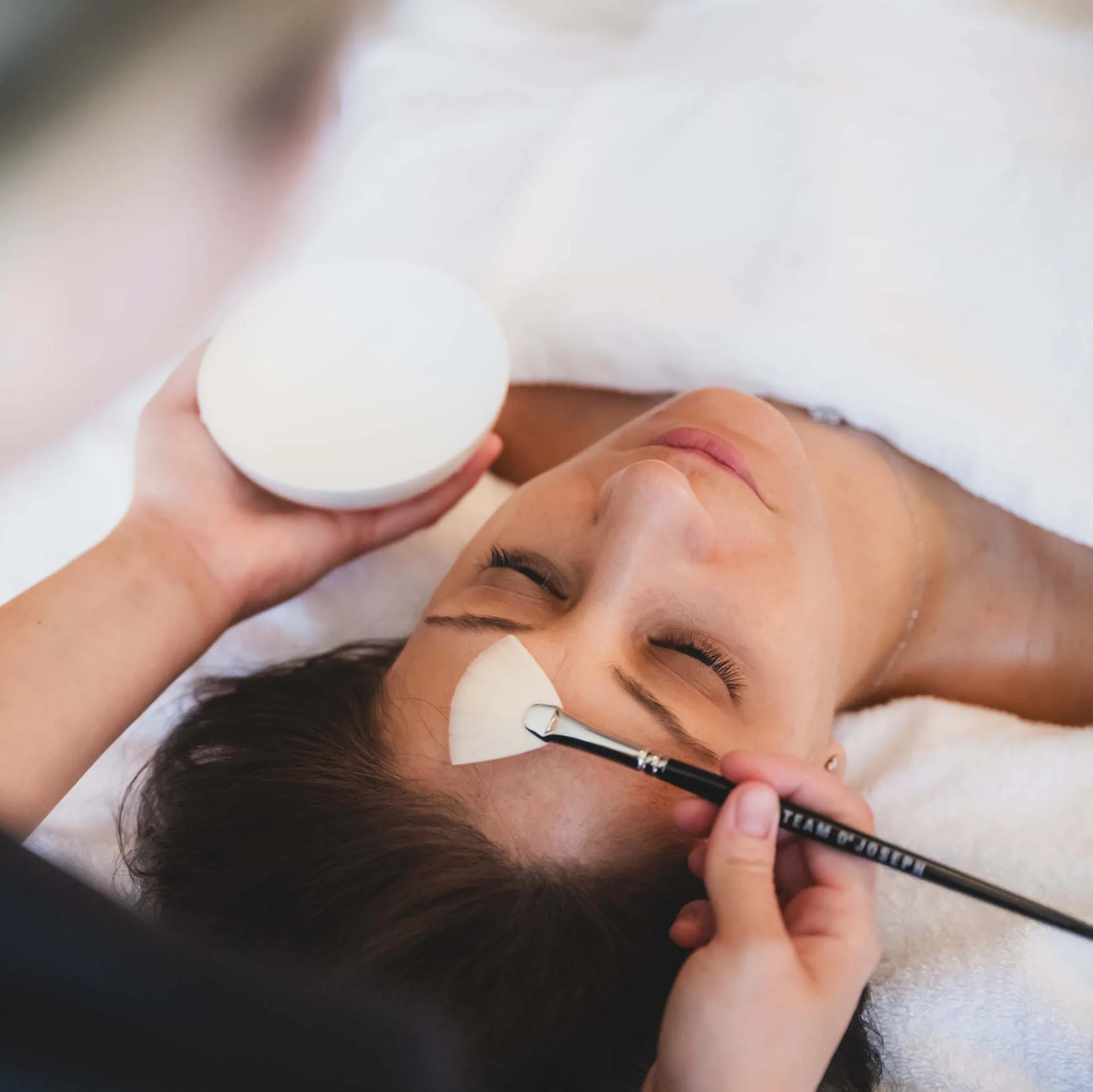 Frau erhält eine Gesichtsmaske bei einer Wellnessbehandlung