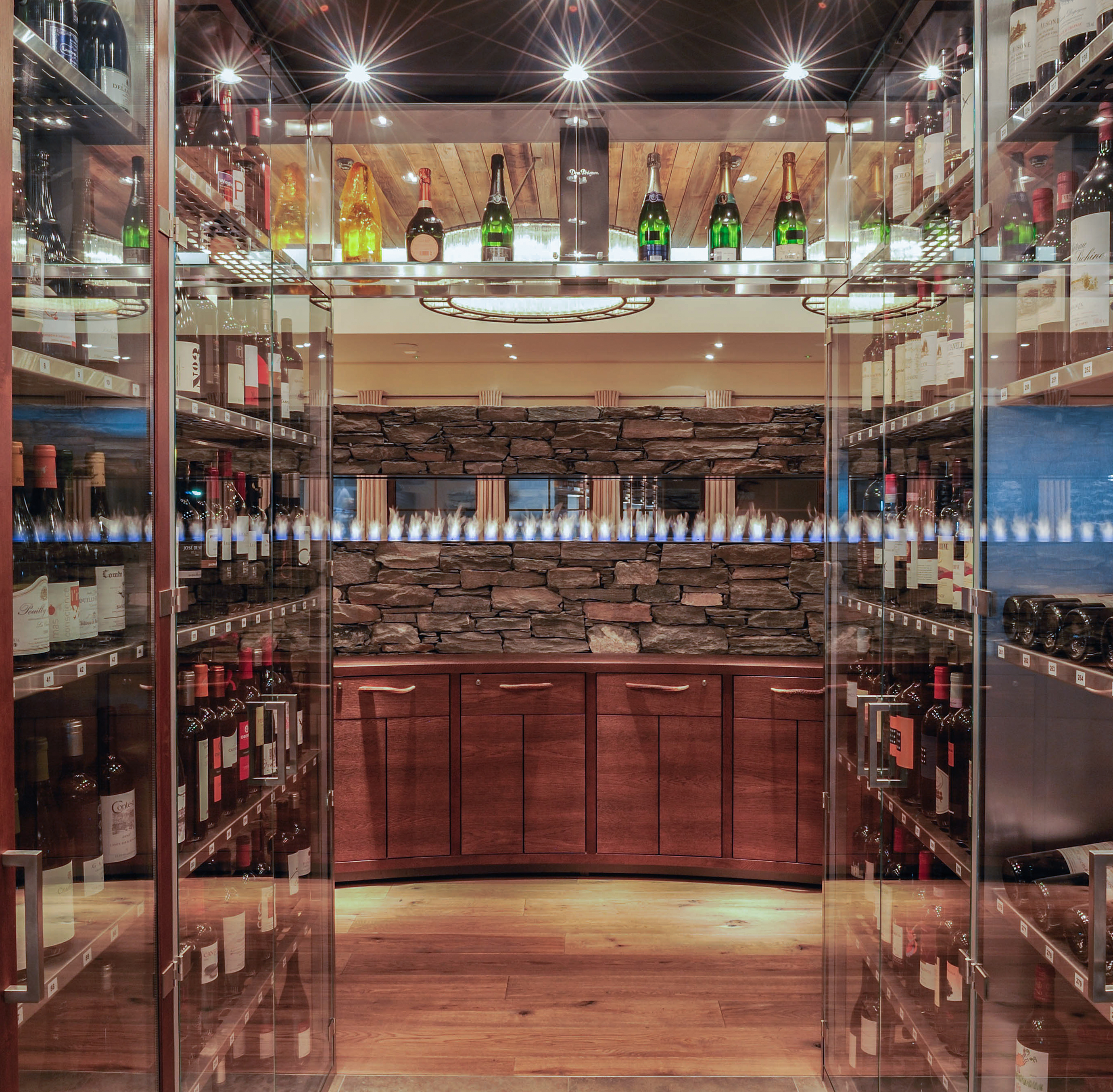 Moderner Weinkeller mit Glastüren und integriertem Kaminfeuer