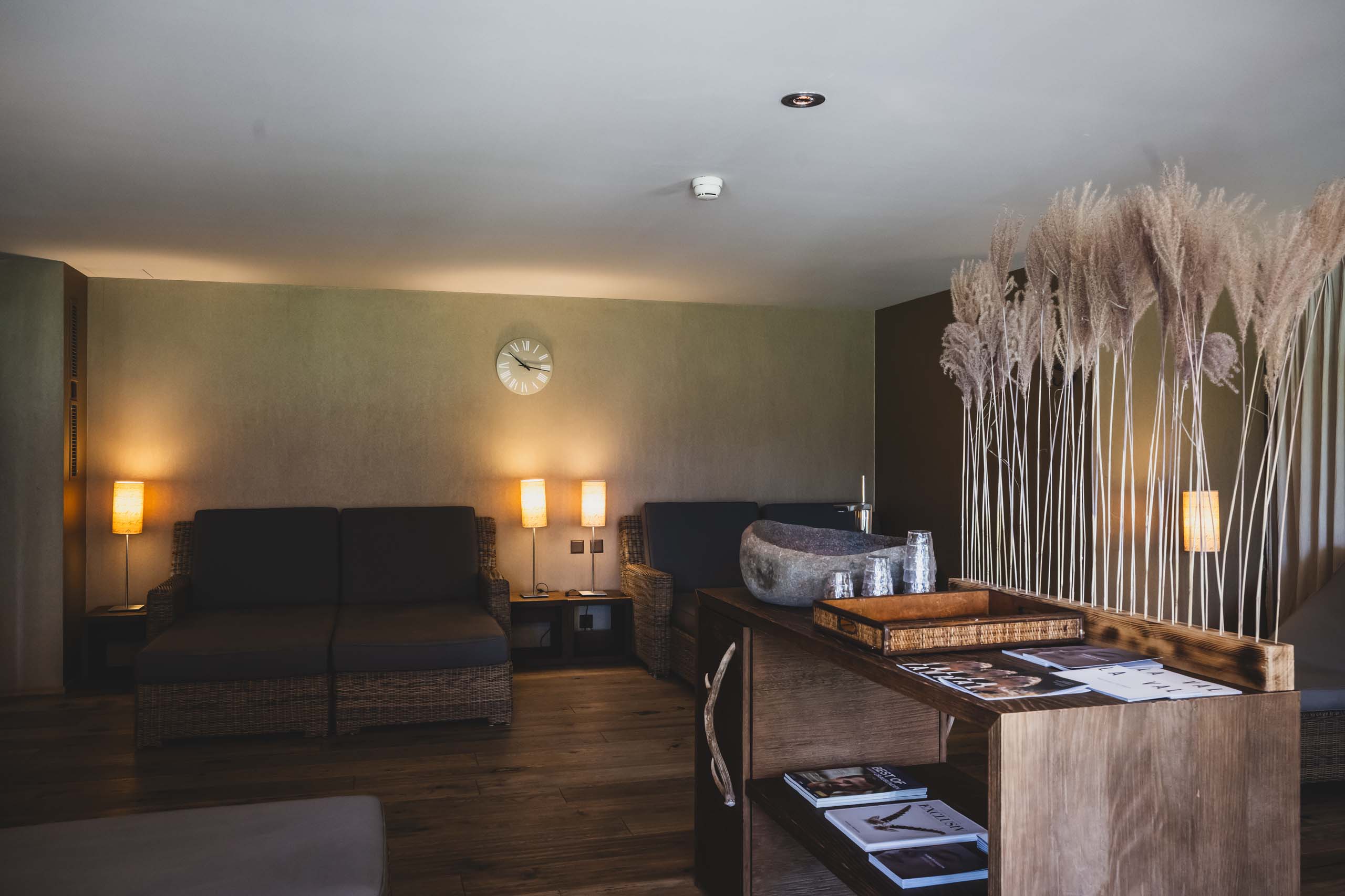 Gemütlicher Warteraum mit Lampen, Uhren und Dekoration aus getrocknetem Gras